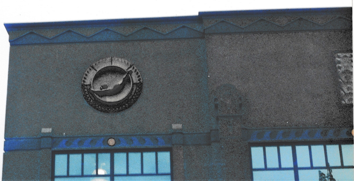 Photo taken Feb. 21998.  Four of these adorn each side of the two Southerly corners of the buidling on Glisan st.  Ordered by Richard W. Sunderleaf, Architect for the "Portland Knitting Company Jantzen".  Current Address in 2018 is 1935 N.E. Glisan St.  Order #128 Glaze "Polychrome" in Leonard Martins order book for Columbia Terra Cotta Co.